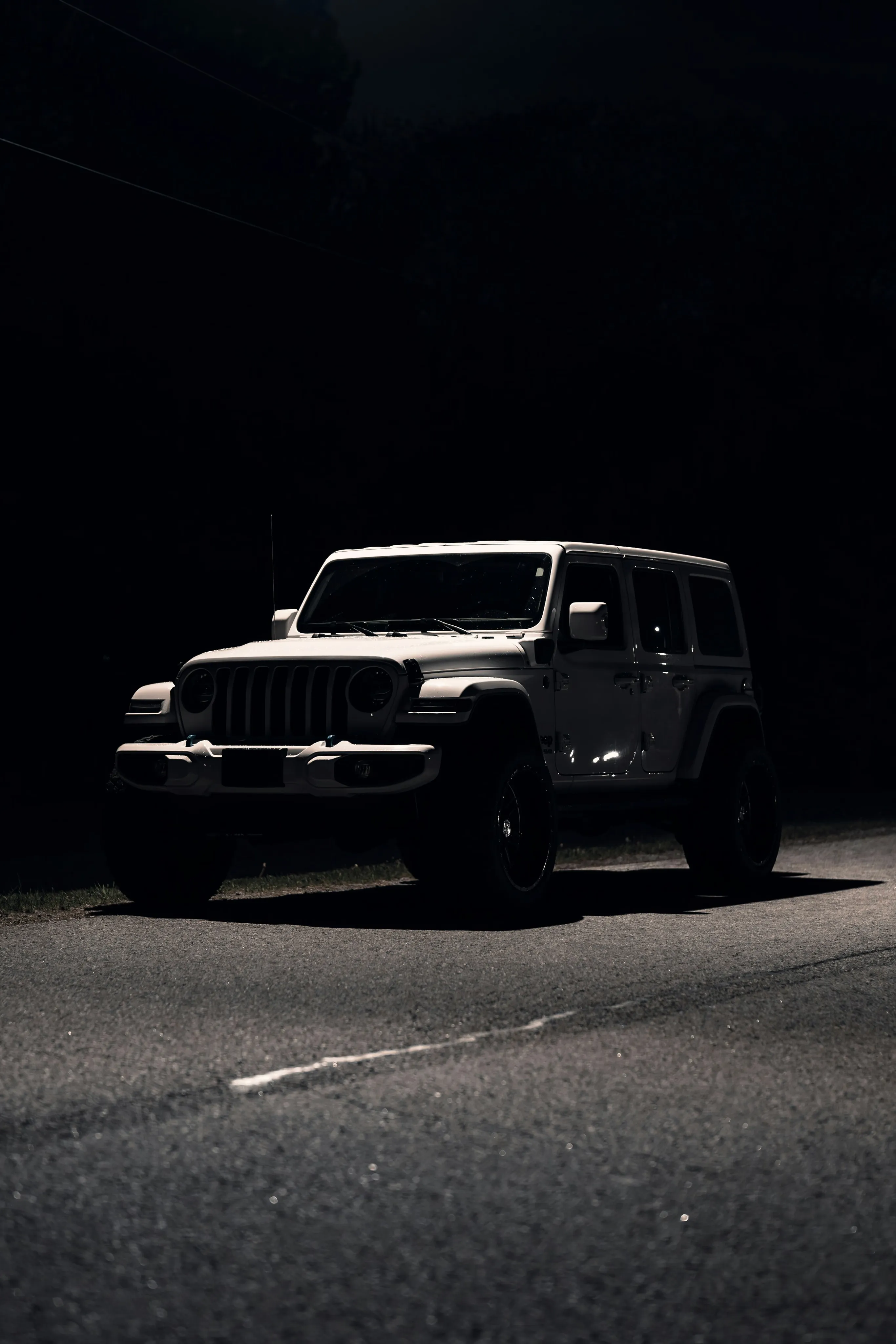 White four-door Jeep Wrangler JL parked at night — ABS module repair for Wrangler JK, JKU and JL in Calgary